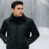 Model wearing a black leather jacket in a winter setting with soft cold light